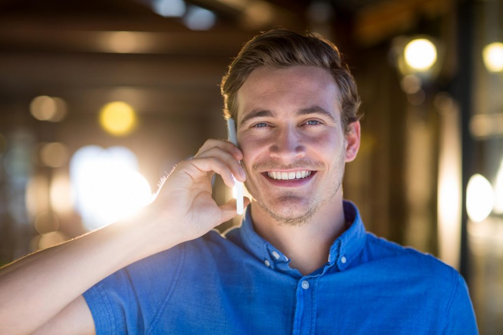 man smiling taking phone call